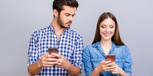 curious-boyfriend-is-spying-his-lovers-smartphone-royalty-free-image-937371458-1557501844.jpg